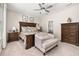 Bright primary bedroom featuring floral bedding, a plush chair, dark wood furniture, and a ceiling fan for added comfort at 3837 Carrick Bend Dr, Kissimmee, FL 34746