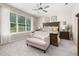 Charming bedroom with floral bedding, a tufted chair, side tables, a ceiling fan, and natural lighting from a large window at 3837 Carrick Bend Dr, Kissimmee, FL 34746