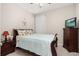 Well-lit bedroom with wood-framed bed, side tables, ceiling fan, and a TV on a chest of drawers at 3837 Carrick Bend Dr, Kissimmee, FL 34746