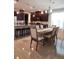 A kitchen dining area boasts dark wood cabinetry, granite counters, a long wooden table, and seating for six at 3837 Carrick Bend Dr, Kissimmee, FL 34746