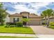 Charming home with a tile roof, well-manicured lawn, and a brick driveway at 3837 Carrick Bend Dr, Kissimmee, FL 34746