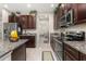 A detailed view of the kitchen featuring granite countertops, stainless steel appliances, and dark cabinetry at 3837 Carrick Bend Dr, Kissimmee, FL 34746