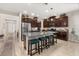 Spacious kitchen with dark cabinets, granite countertops, a central island with barstools, and stainless steel appliances at 3837 Carrick Bend Dr, Kissimmee, FL 34746