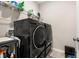 Well-equipped laundry room featuring modern black Samsung washer and dryer units, accompanied by overhead shelving at 3837 Carrick Bend Dr, Kissimmee, FL 34746