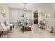 A charming living room featuring a light blue sofa, marble floors, and natural light from two windows at 3837 Carrick Bend Dr, Kissimmee, FL 34746