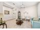 Inviting living room with marble floors, blue sofa, neutral decor, and a decorative light fixture at 3837 Carrick Bend Dr, Kissimmee, FL 34746