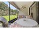 Relaxing screened patio with view of the landscaped backyard, featuring a ceiling fan and comfortable seating area at 3837 Carrick Bend Dr, Kissimmee, FL 34746