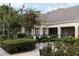 Clubhouse exterior with landscaped grounds, featuring manicured shrubs, shade trees, picnic tables and grilling area at 4008 San Sebastian Dr # 105, Kissimmee, FL 34741