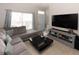 Comfortable living room featuring a sectional sofa, entertainment center, and ample natural light at 4008 San Sebastian Dr # 105, Kissimmee, FL 34741