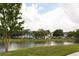 Scenic water view of colorful townhouses reflecting in the lake, framed by lush trees and green lawns at 4008 San Sebastian Dr # 105, Kissimmee, FL 34741