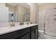 Bathroom featuring double sinks, a modern shower with marble tile, and ample counter space at 4547 Narrative Ln, Kissimmee, FL 34746