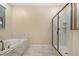 Clean bathroom featuring a soaking tub, a walk-in shower, and marble-look tile flooring at 4547 Narrative Ln, Kissimmee, FL 34746