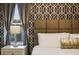 Close up on a stylish bedroom with geometric wallpaper and neutral toned decor at 4547 Narrative Ln, Kissimmee, FL 34746