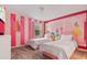 Themed bedroom with pink and white walls, twin beds and carpeted floors at 4547 Narrative Ln, Kissimmee, FL 34746