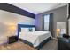 This modern bedroom features blue accents and a textured wall panel, combining comfort and style at 4547 Narrative Ln, Kissimmee, FL 34746
