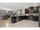 Open kitchen with black cabinets, island, and stainless steel appliances, flowing into the living and dining areas at 4547 Narrative Ln, Kissimmee, FL 34746