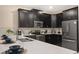 Modern kitchen with stainless steel appliances, white countertops, and dark cabinetry at 4547 Narrative Ln, Kissimmee, FL 34746