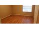 Cozy bedroom with neutral walls, wood-look flooring, and a window allowing natural light to fill the room at 5287 Images Cir # 303, Kissimmee, FL 34746