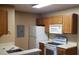 Functional kitchen with white appliances, wood cabinets, and a stainless steel sink set in a neutral color scheme at 5287 Images Cir # 303, Kissimmee, FL 34746