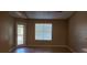 Bright living room featuring wood floors, a large window with blinds, and a sliding glass door to the exterior at 5287 Images Cir # 303, Kissimmee, FL 34746