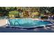 Community pool surrounded by lounge chairs, trees, and fencing for a relaxing recreational area at 5287 Images Cir # 303, Kissimmee, FL 34746