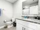 Well-maintained bathroom featuring a granite vanity, sink, mirror, toilet and towel rack at 536 Bristol Cir, Kissimmee, FL 34758