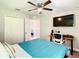 Bright bedroom featuring a ceiling fan, desk, TV, closet and doorway to another room at 536 Bristol Cir, Kissimmee, FL 34758