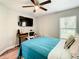 This bedroom has a ceiling fan, bed with blue comforter, desk, and a window at 536 Bristol Cir, Kissimmee, FL 34758