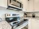 Modern kitchen featuring granite countertops, stainless steel appliances, and white cabinetry at 536 Bristol Cir, Kissimmee, FL 34758