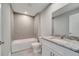 Bathroom featuring tiled walls, a bathtub, granite countertop vanity, and modern fixtures offering a relaxing space at 547 Viceroy Ct, Kissimmee, FL 34758