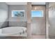 Bright bathroom with a soaking tub and a tiled walk-in shower with windows at 547 Viceroy Ct, Kissimmee, FL 34758