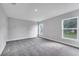 Bright bedroom with neutral gray walls, plush carpeting, and large windows overlooking the yard at 547 Viceroy Ct, Kissimmee, FL 34758