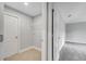 Hallway view into a laundry room with a white wire rack for storage and tile flooring at 547 Viceroy Ct, Kissimmee, FL 34758