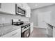 Modern kitchen boasts stainless steel appliances, granite countertops, and sleek white cabinetry at 547 Viceroy Ct, Kissimmee, FL 34758
