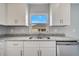 Bright kitchen features white cabinets, granite countertops, stainless steel dishwasher, and window with blue sky view at 549 Viceroy Ct, Kissimmee, FL 34758