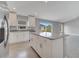 Modern kitchen boasts an island with granite countertops, white cabinetry, and stainless steel appliances at 549 Viceroy Ct, Kissimmee, FL 34758