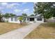 Charming one story home featuring mature landscaping, palm tree, gray shutters, and a concrete driveway at 609 Doheny Way, Casselberry, FL 32707