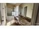 Bright bathroom featuring a double vanity, large mirror, and glass enclosed shower/tub at 7110 Red Lantern Dr # 23, Harmony, FL 34773