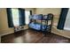 Cozy bedroom featuring a bunk bed with blue bedding and dark wood laminate flooring at 7110 Red Lantern Dr # 23, Harmony, FL 34773