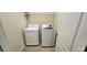 Bright laundry room features white front load washer and dryer units with overhead shelving at 7110 Red Lantern Dr # 23, Harmony, FL 34773