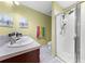 Bathroom featuring a walk-in shower, double sink vanity, and bright green walls at 739 Jefferson, Davenport, FL 33837