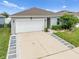 Charming one-story home with a two-car garage, walkway, and well-maintained landscaping and grass at 739 Jefferson, Davenport, FL 33837
