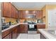 Well-equipped kitchen featuring dark wood cabinetry, stainless steel appliances, and tile flooring at 739 Jefferson, Davenport, FL 33837