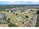 Scenic aerial shot of a lush golf course community with a pond and surrounding residential properties on a sunny day at 7458 Gathering Dr, Kissimmee, FL 34747