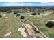 Expansive aerial view of a golf course with pristine fairways, mature trees, and scenic water features at 7458 Gathering Dr, Kissimmee, FL 34747