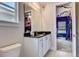 Bathroom with a vanity with black granite countertop, white cabinets, and a view into a mural-decorated bedroom at 7458 Gathering Dr, Kissimmee, FL 34747