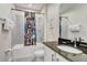 Bathroom featuring a tub with a floral curtain, gray tile, and a vanity with a black granite countertop at 7458 Gathering Dr, Kissimmee, FL 34747