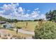 Picturesque golf course view featuring lush green fairways, mature trees, and blue skies with scattered clouds at 7458 Gathering Dr, Kissimmee, FL 34747