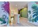 Hallway featuring beautiful botanical murals, custom pink flower accents, and light wood flooring at 7458 Gathering Dr, Kissimmee, FL 34747