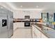 Bright kitchen featuring white cabinets, stainless steel appliances, and stylish backsplash at 7458 Gathering Dr, Kissimmee, FL 34747